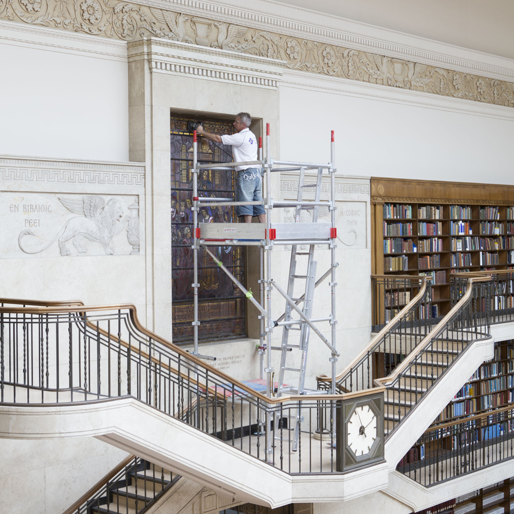 Workman on ladder in large room