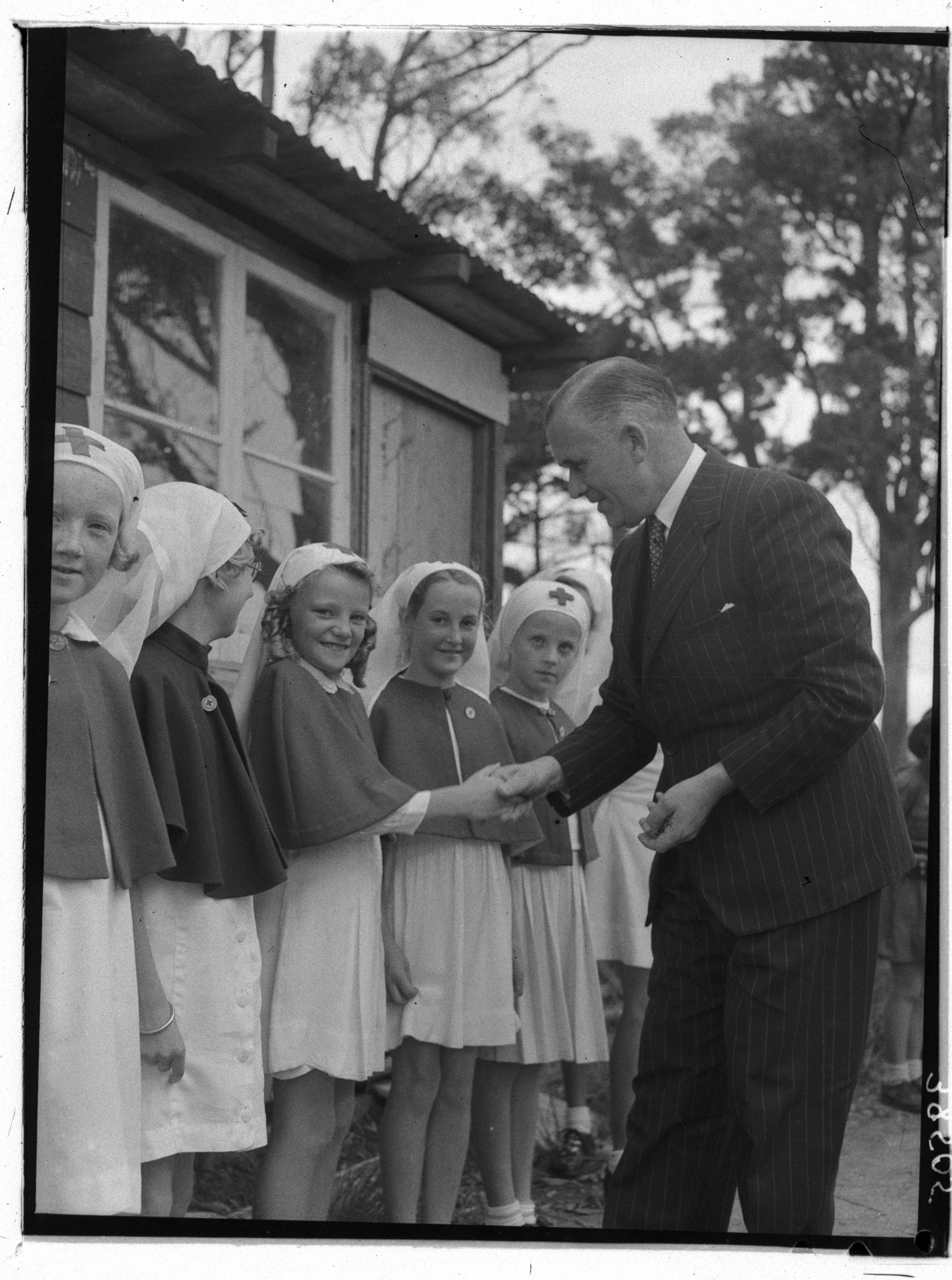 Clive Evatt KC MLA greets members of the Junior Red Cross