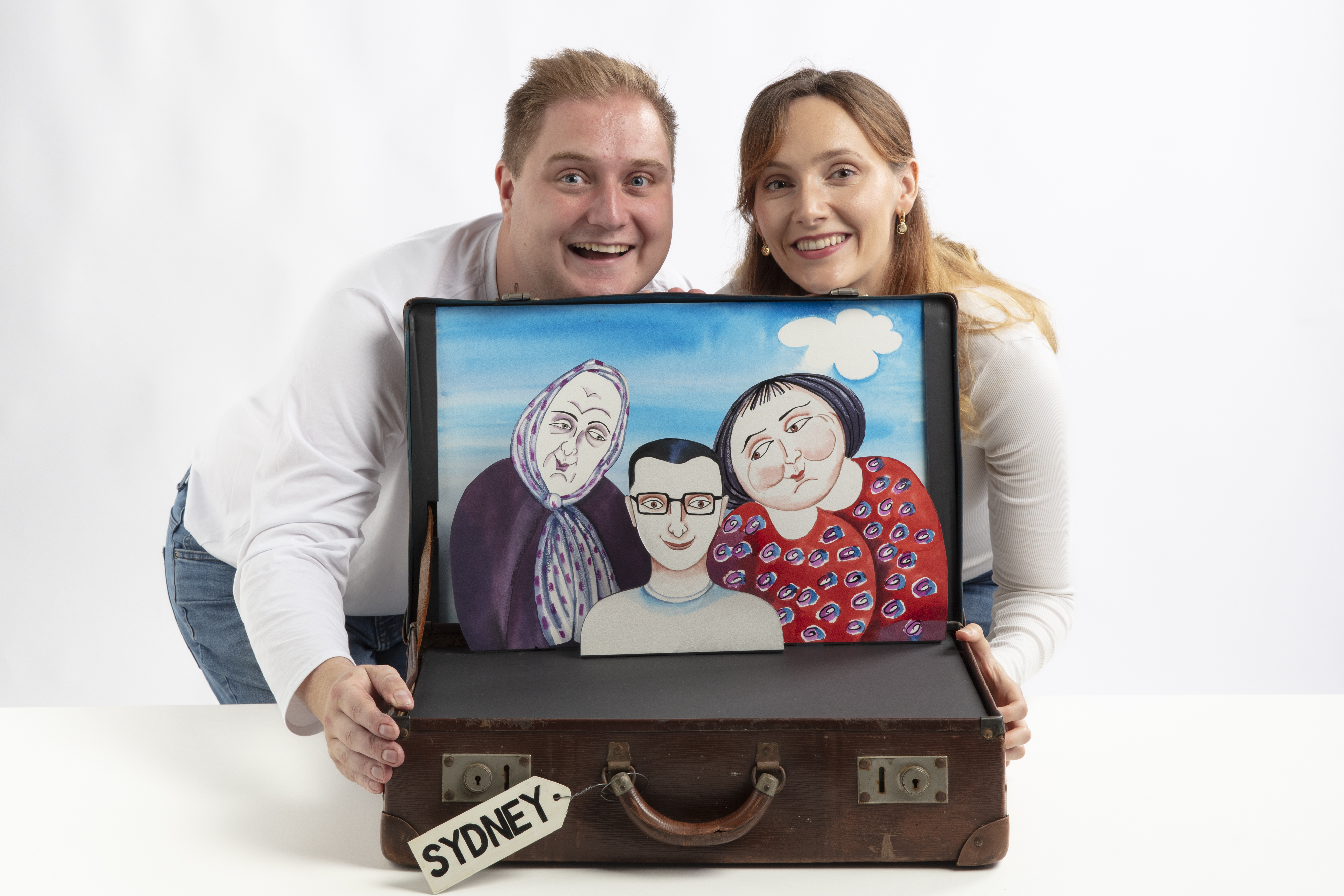 male and female actor looking over puppet suitxcase