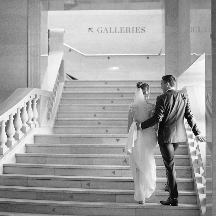 Image of a bride and groom on marble staircase.