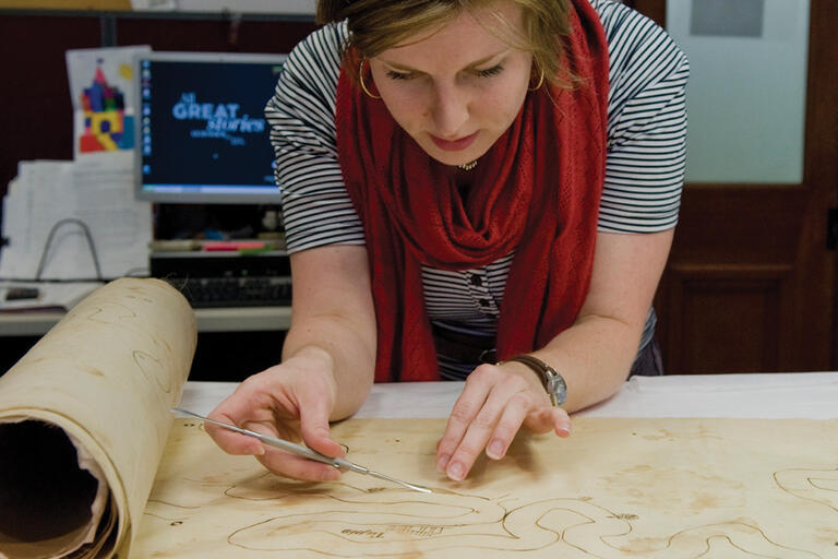 Woman carefully repairing old map