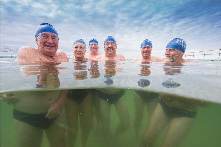 Six people swimming in an outdoor pool