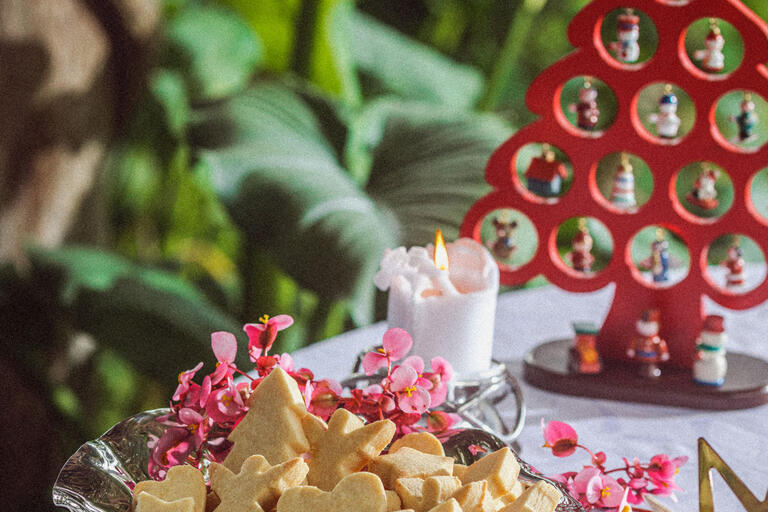 Table with a bowl of shortbread cookies and Christmas decorations.