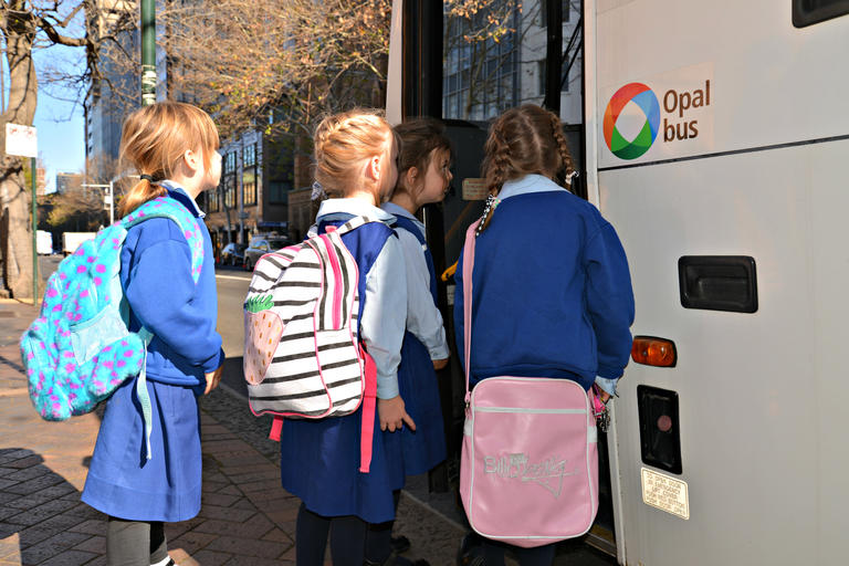 four five year old girls boarding a bus