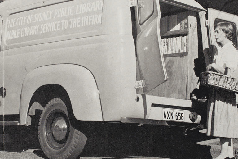 Woman with basket of books next to van b/w photo