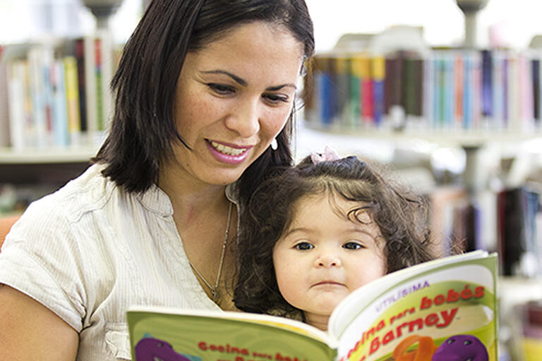 Woman reading a book to young girl - Blacktown Library