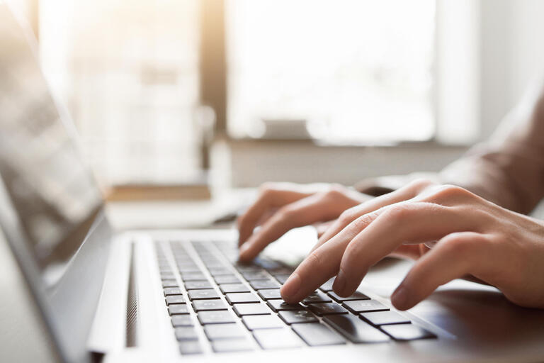 Hands typing on a keyboard