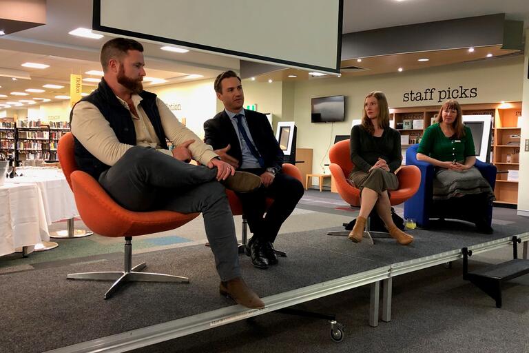 Four people sitting on a stage