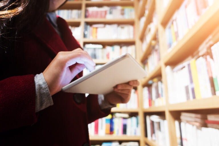 Person reading ipad in a library