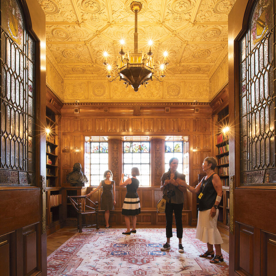 Girl being photographed by another girl in sunlit golden room