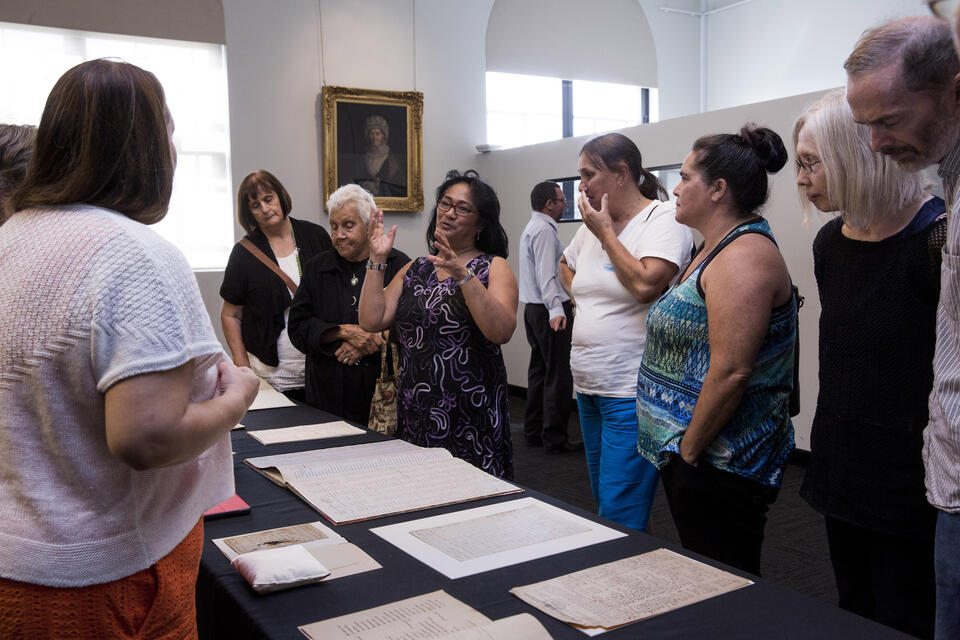 Group of people looking at manuscripts on a table 