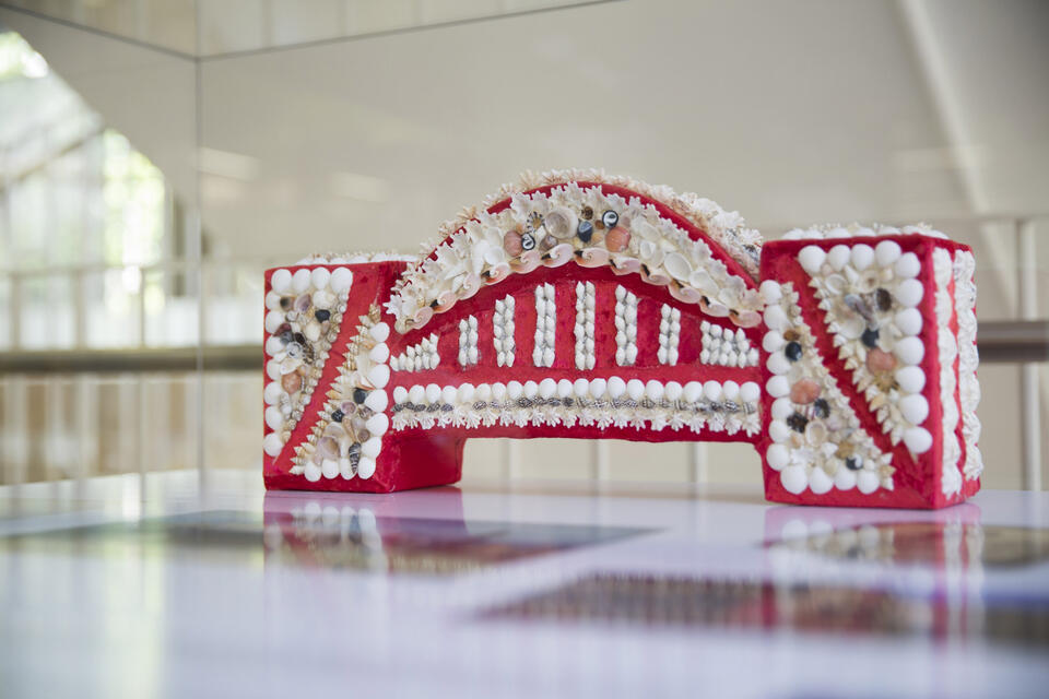 A small red bridge covered by white shells