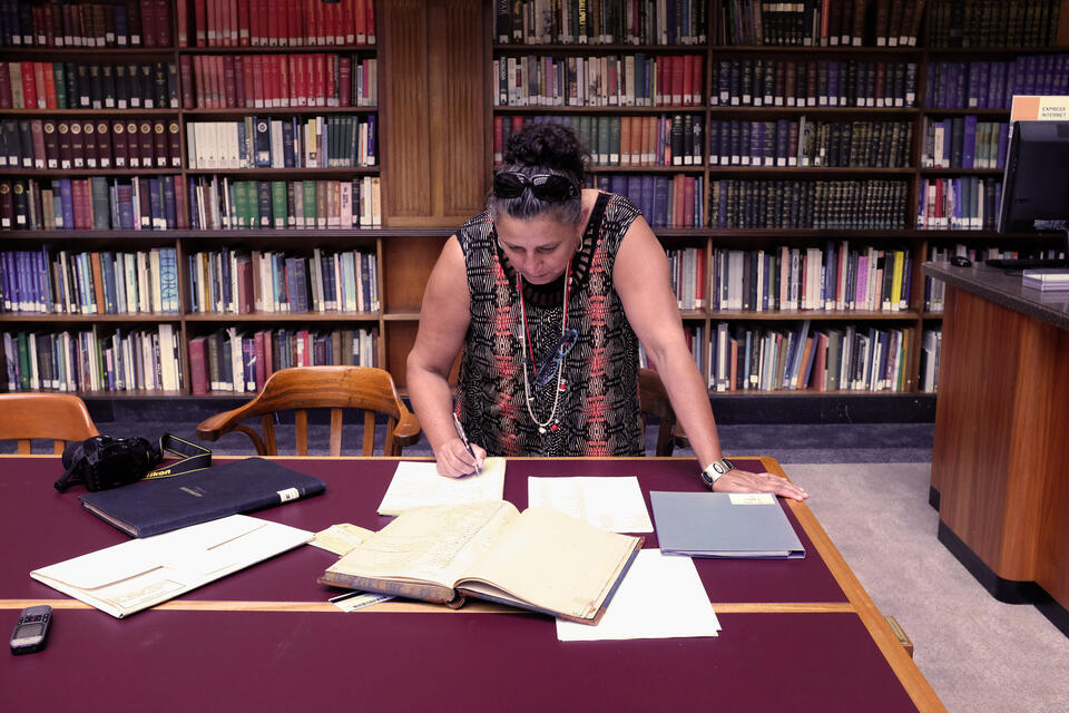 A woman looking at some papers on a table