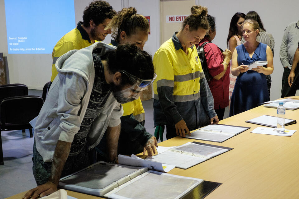 People looking at manuscripts on a table