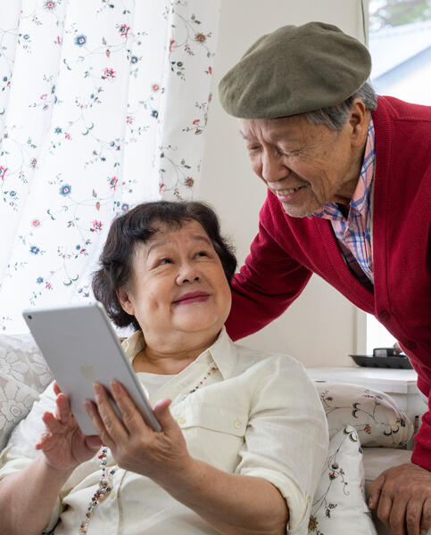 Older couple using an iPad and smiling