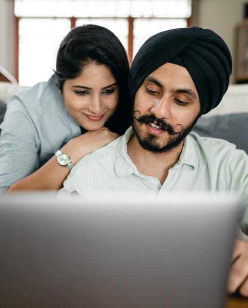 Cheerful couple looking at laptop and smiling