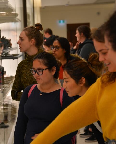 A group of people looking at items in a display case