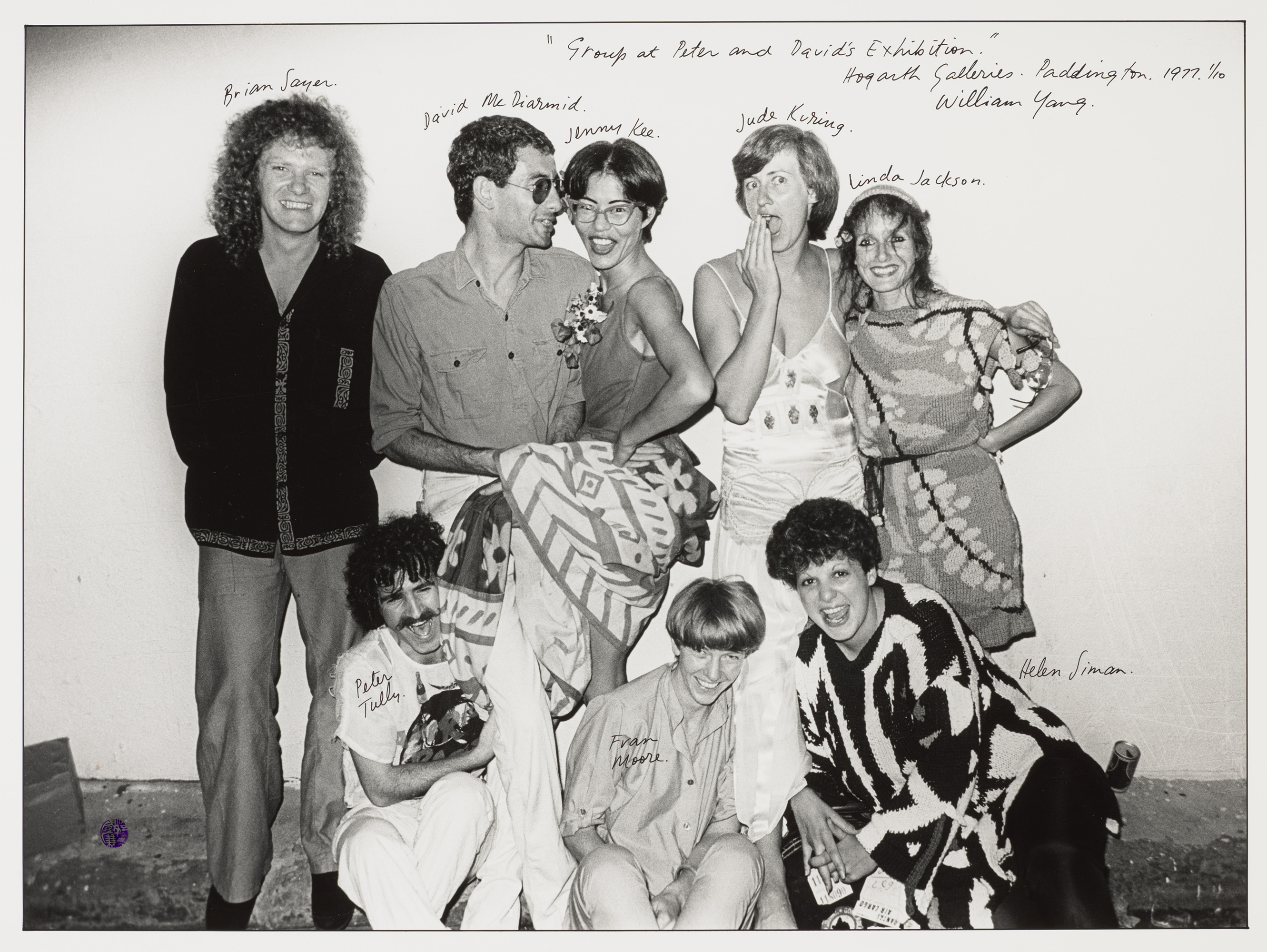 Black and white photo of a group of people standing together posing.